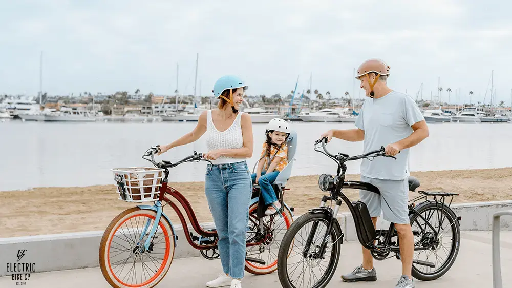Family riding E-bikes at the beach